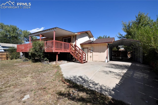 back of property featuring a wooden deck and a carport