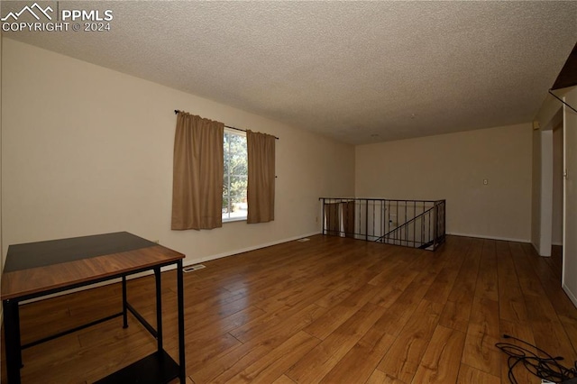 empty room featuring hardwood / wood-style flooring and a textured ceiling