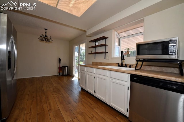 kitchen with appliances with stainless steel finishes, a healthy amount of sunlight, sink, and dark hardwood / wood-style floors