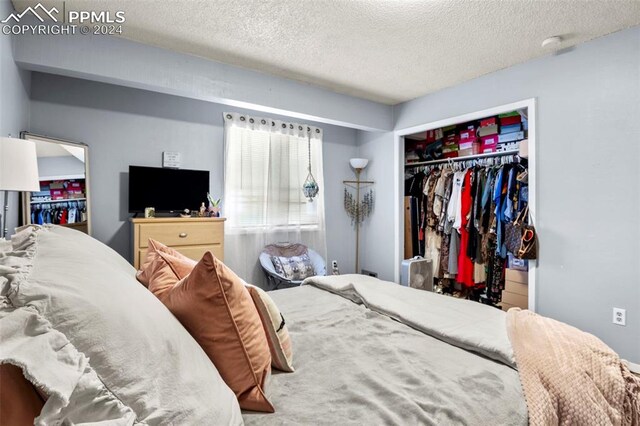 bedroom with a textured ceiling and a closet