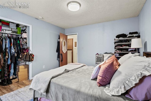 bedroom featuring a textured ceiling, a closet, and hardwood / wood-style floors