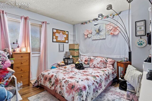 bedroom with a textured ceiling and hardwood / wood-style flooring