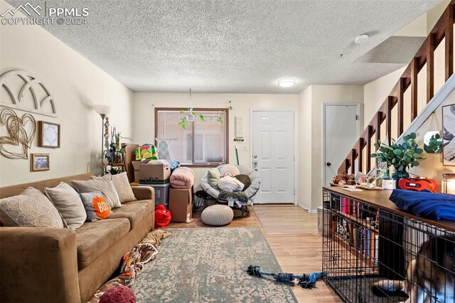 living room with light wood-type flooring and a textured ceiling