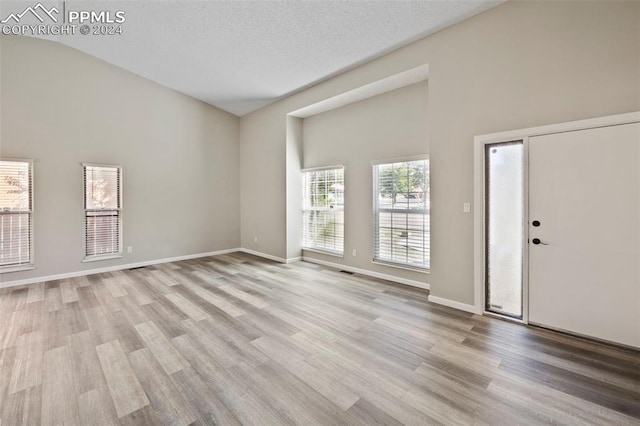 entrance foyer featuring a textured ceiling, light hardwood / wood-style flooring, and plenty of natural light