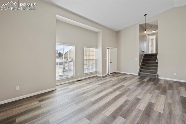 unfurnished living room with lofted ceiling and hardwood / wood-style floors