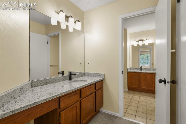 bathroom featuring a textured ceiling, vanity, and tile patterned floors