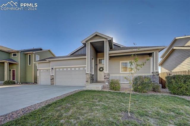 craftsman inspired home with a garage and a front lawn