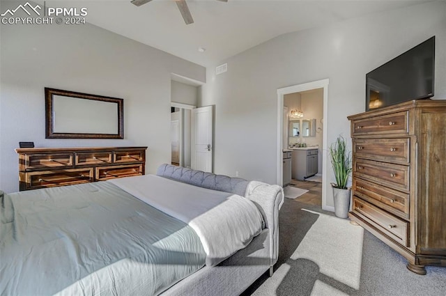 carpeted bedroom featuring lofted ceiling, ensuite bath, and ceiling fan