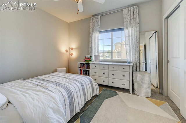 bedroom with ceiling fan, a closet, and dark colored carpet