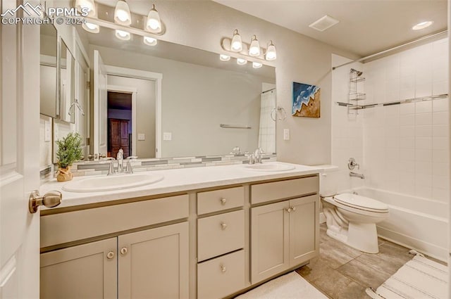 full bathroom featuring tile patterned floors, tiled shower / bath combo, vanity, and toilet