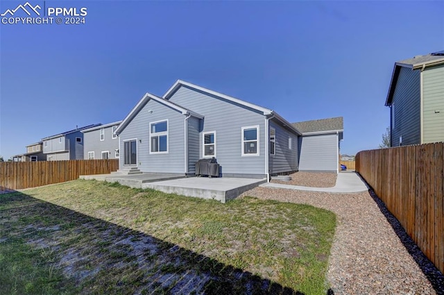 back of house with a yard and a patio area