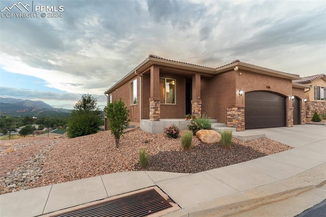 view of front of home with a garage and a mountain view