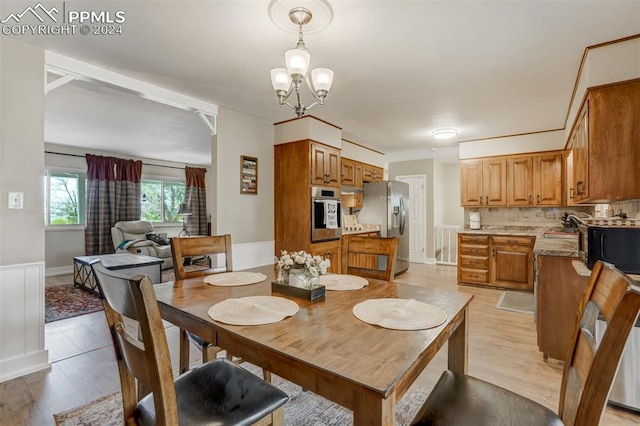 dining area featuring light hardwood / wood-style floors, an inviting chandelier, and sink