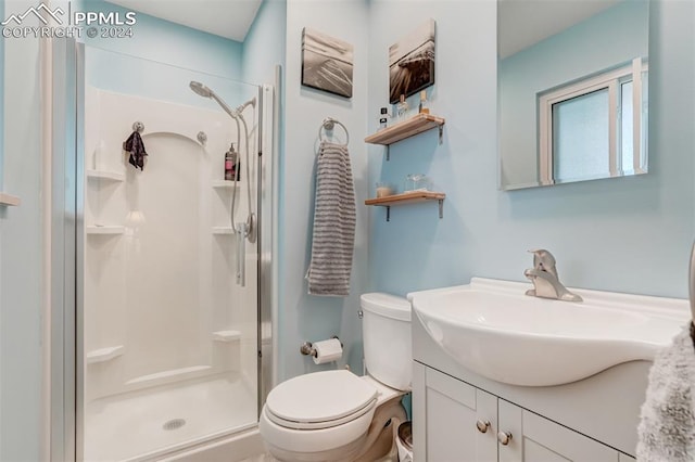 bathroom with walk in shower, vanity, and toilet