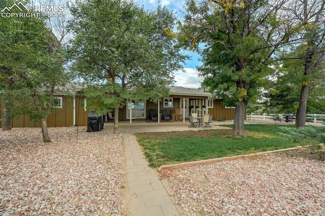 view of front of property with a front yard and a patio area