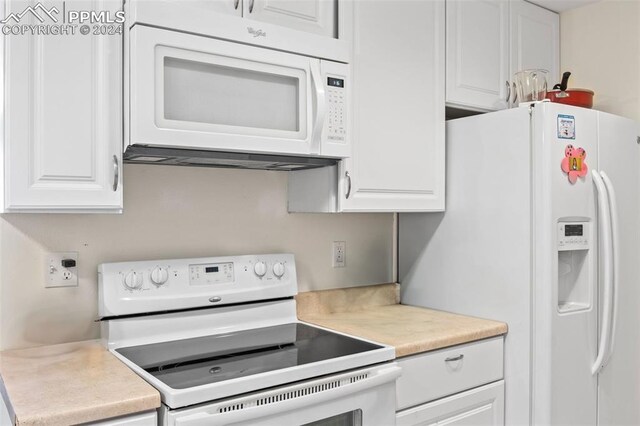 kitchen with white cabinets and white appliances