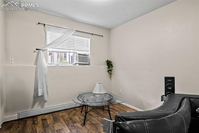 living area with cooling unit, baseboard heating, and hardwood / wood-style floors