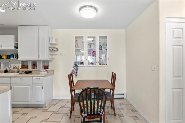 dining area featuring sink and a baseboard heating unit