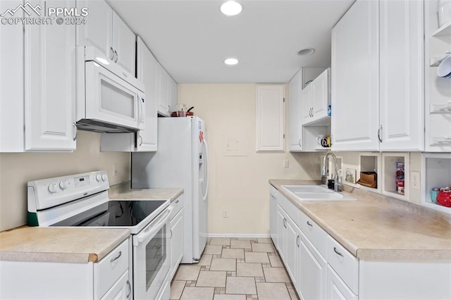 kitchen with sink, white appliances, and white cabinetry