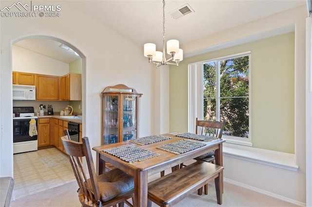 dining area featuring a notable chandelier and lofted ceiling