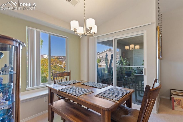 dining space with light carpet, vaulted ceiling, and a chandelier