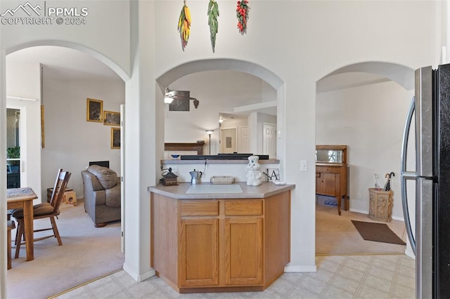 kitchen featuring light carpet, stainless steel fridge, and sink