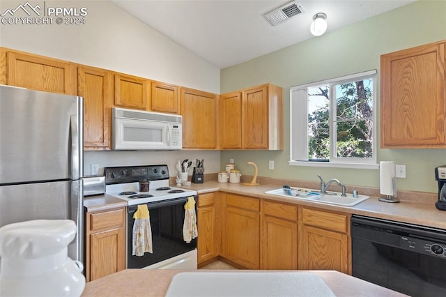 kitchen featuring white appliances, vaulted ceiling, and sink