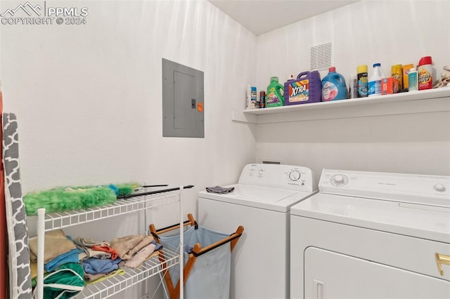 clothes washing area featuring electric panel and independent washer and dryer