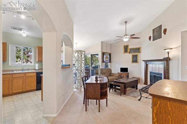 living room with sink, vaulted ceiling, a fireplace, light carpet, and ceiling fan