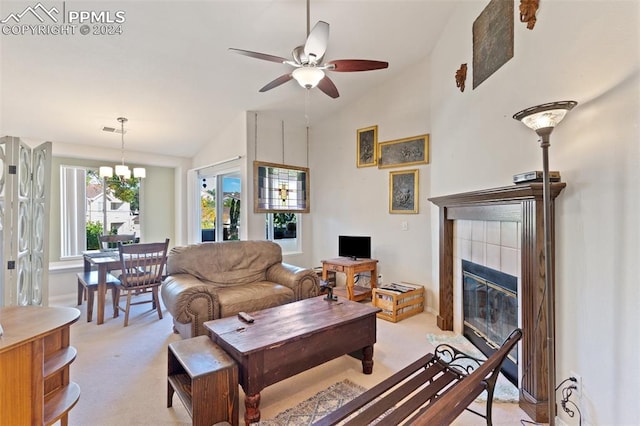 living room with ceiling fan with notable chandelier, light colored carpet, high vaulted ceiling, and a fireplace