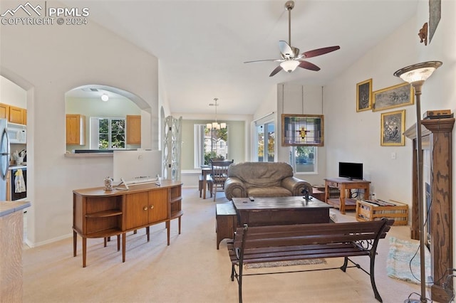 carpeted living room with ceiling fan with notable chandelier and lofted ceiling