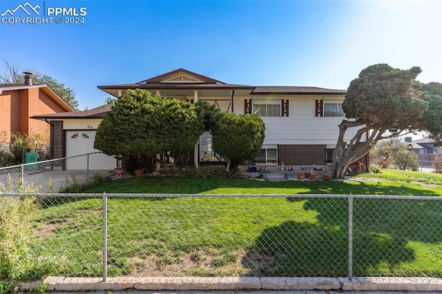 view of front of property with a garage and a front lawn