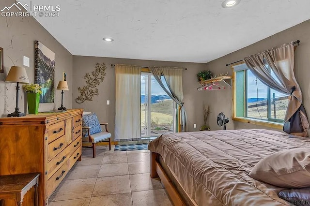 tiled bedroom featuring a mountain view and multiple windows