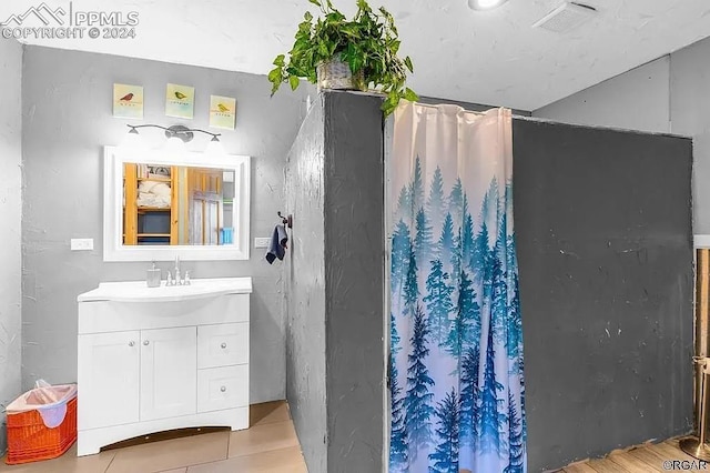 bathroom featuring hardwood / wood-style flooring, walk in shower, and vanity