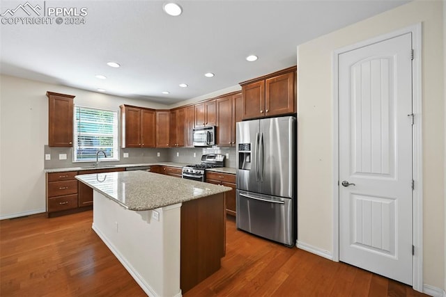 kitchen featuring a kitchen island, sink, dark wood-type flooring, and stainless steel appliances