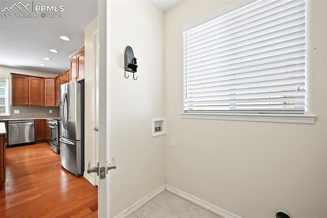 kitchen with light hardwood / wood-style flooring and appliances with stainless steel finishes