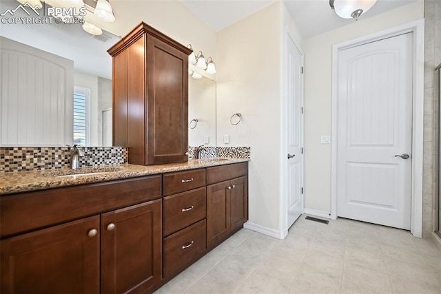 bathroom with tile patterned flooring, an enclosed shower, vanity, and tasteful backsplash