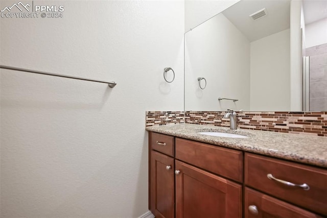 bathroom featuring vanity and tasteful backsplash