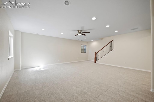 empty room featuring ceiling fan and light colored carpet