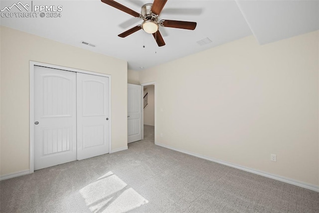 unfurnished bedroom featuring a closet, ceiling fan, and light colored carpet