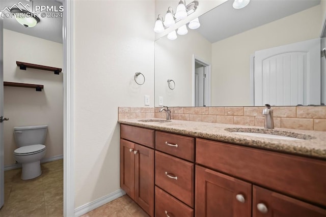 bathroom with vanity, toilet, tasteful backsplash, and tile patterned floors