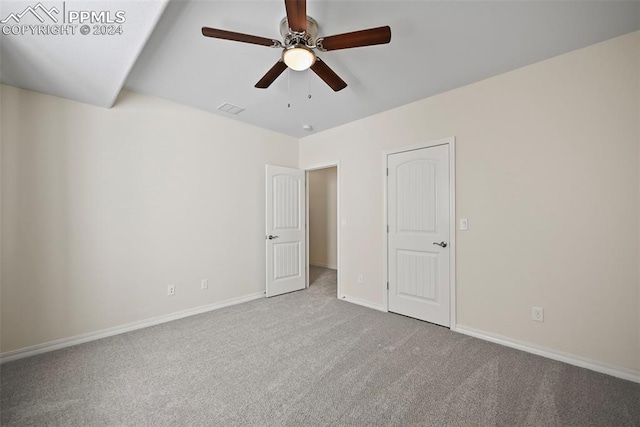 carpeted spare room featuring ceiling fan