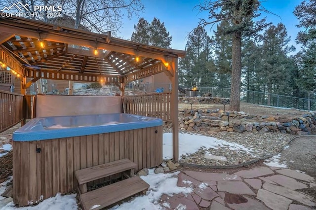 snow covered patio featuring a hot tub and a gazebo