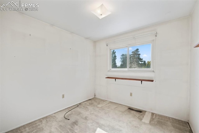 carpeted empty room featuring visible vents
