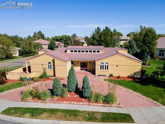 mediterranean / spanish home with a front lawn