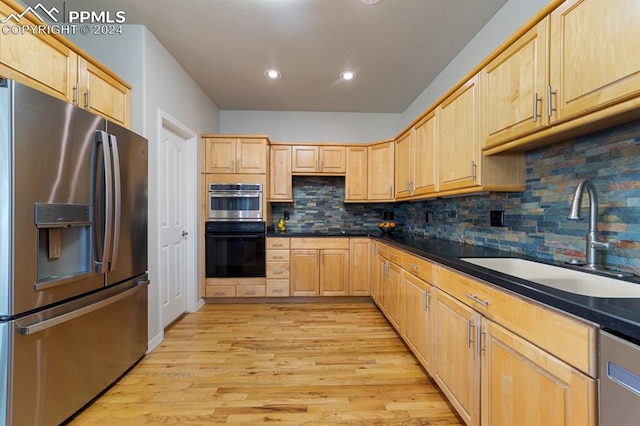 kitchen featuring light brown cabinets, stainless steel appliances, sink, and light hardwood / wood-style flooring