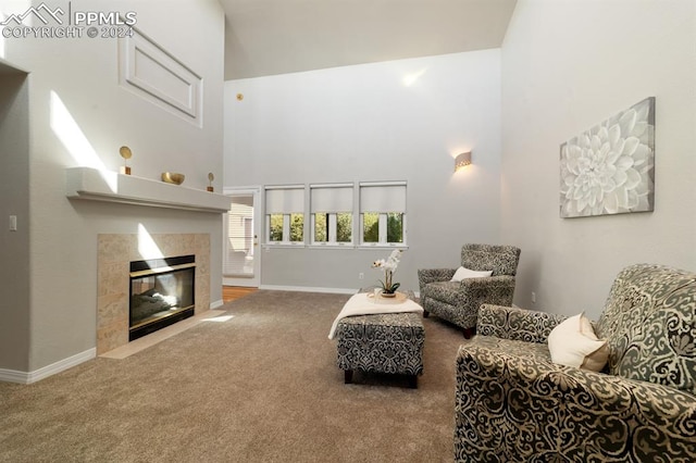 carpeted living room with a towering ceiling and a tiled fireplace