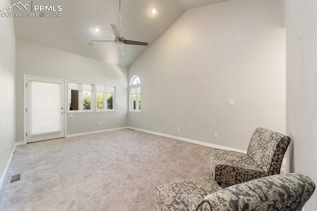 living area featuring ceiling fan, carpet, and high vaulted ceiling