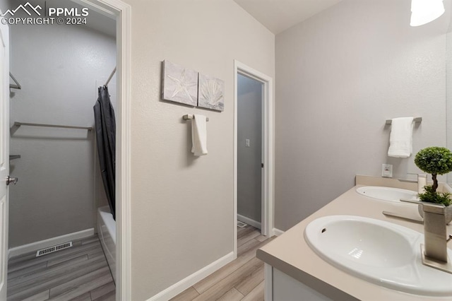 bathroom featuring vanity, hardwood / wood-style flooring, and shower / bathtub combination with curtain