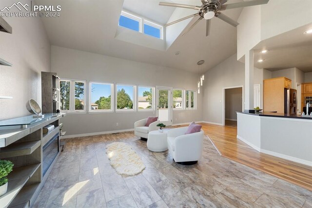 living room featuring ceiling fan, light hardwood / wood-style floors, and high vaulted ceiling